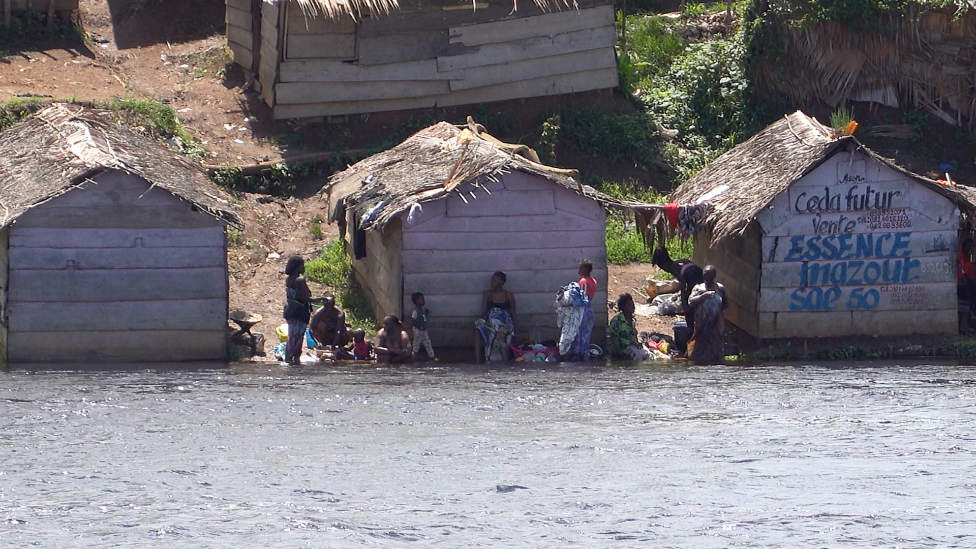 more developed village with women washing clothes in river